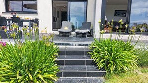 A modern house with a patio area featuring outdoor furniture and a variety of plants. - Stunning private villa for 6 people with WIFI, TV, terrace and pets allowed (Pentrez)