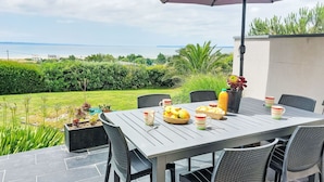 An outdoor dining area with a table set for two, surrounded by chairs, and an umbrella providing shade. - Stunning private villa for 6 people with WIFI, TV, terrace and pets allowed (Pentrez)