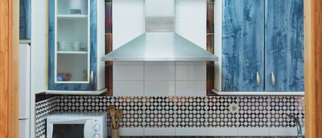 A kitchen with a microwave, stove, and cabinets.