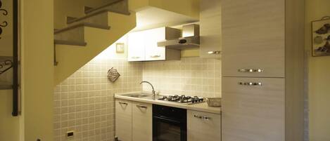 Een koffiezetapparaat/waterkoker, kookgerei, borden en bestek