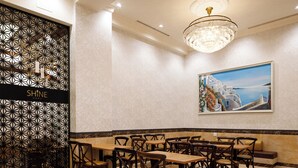 A dining area with a long table and multiple chairs, a decorative wall with a geometric pattern, and a chandelier. - FIVE HOTEL OSAKA (Osaka)