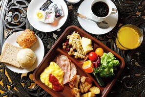 A meal tray with toast, eggs, ham, and vegetables.