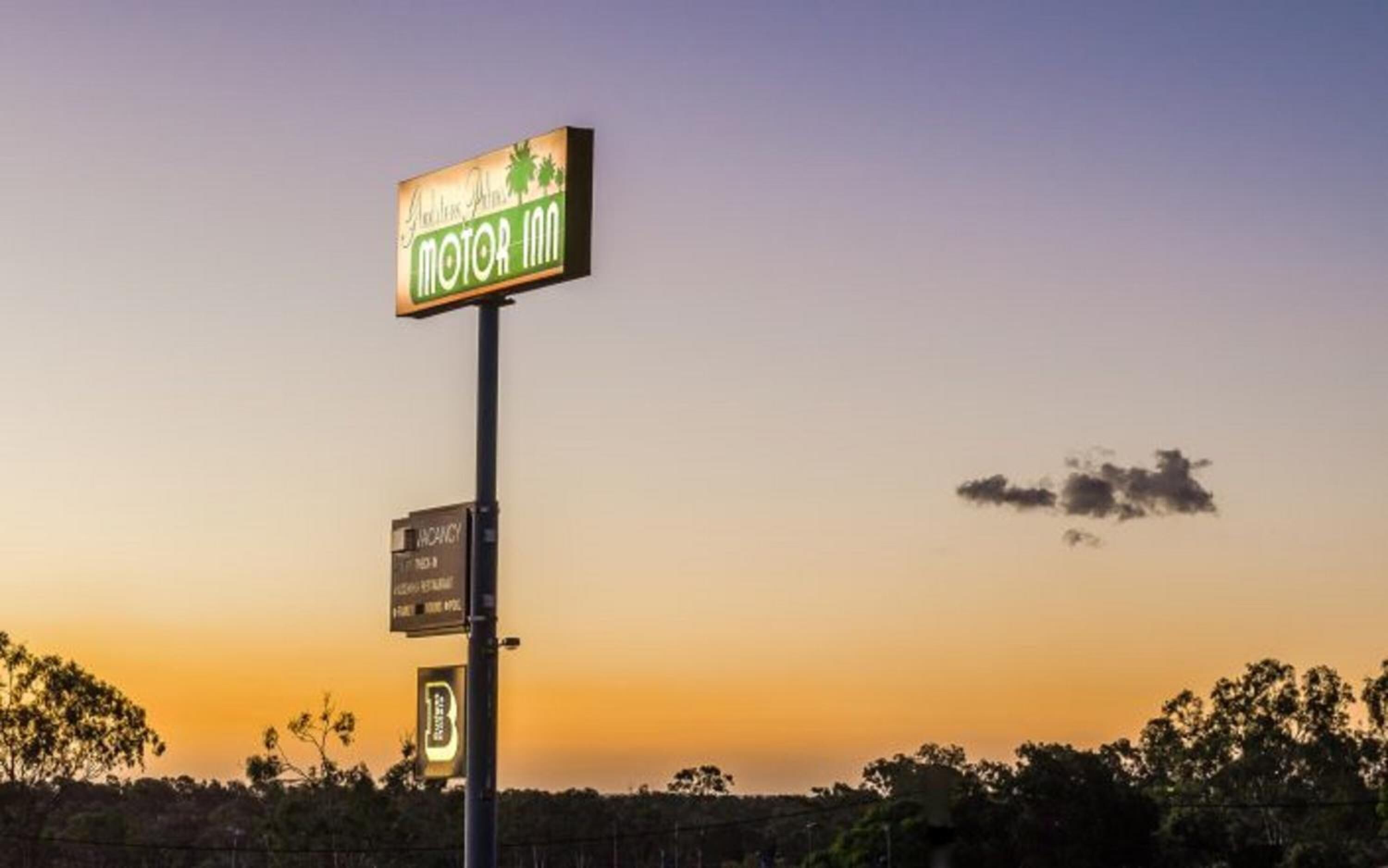 En skylt för motellet, med en grön och vit färgskala, som visar namnet och eventuellt vilka bekvämligheter eller tjänster som erbjuds.