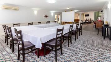 Una sala de conferencias con una larga mesa, varias sillas y una alfombra estampada.