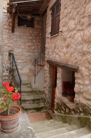 Step into a charming heritage building with a rustic stone staircase and wooden accents.