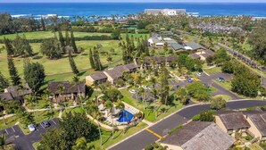 Un resort con un campo da golf, una piscina e vista sull'oceano.
