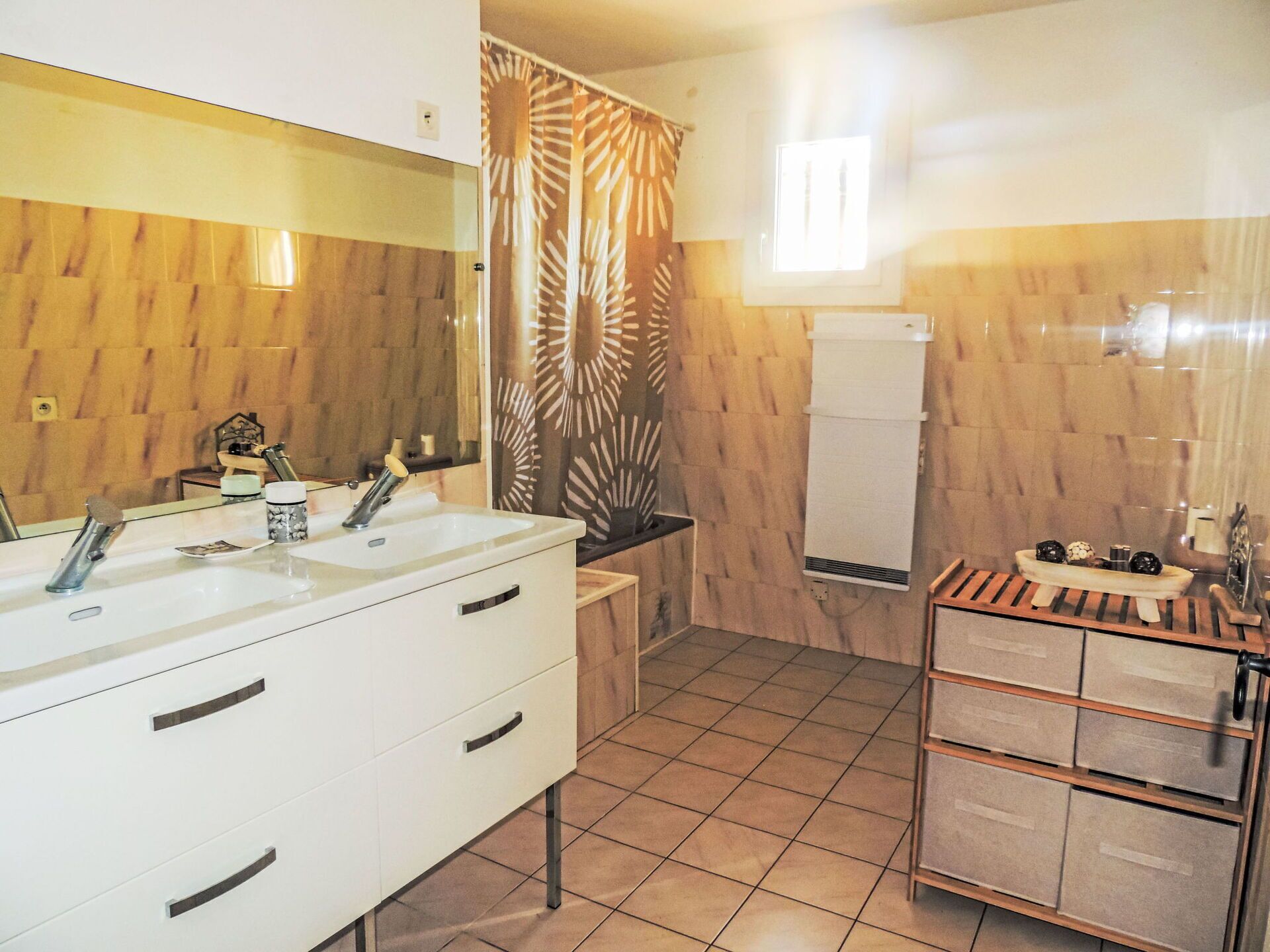 Un baño con lavamanos doble, paneles de madera en la pared, un perchero y un espejo.