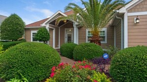 A residential house with a well-maintained garden, including hedges and flowering plants. - 6 BR, Huge Pool/Jacuzzi, Movie Theater, Luxurious Yard, Discounted Golf Cart (Destin)
