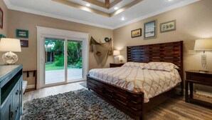 A bedroom with a large bed, a ceiling fan, a sliding glass door to the outside, and a wooden headboard. - 6 BR, Huge Pool/Jacuzzi, Movie Theater, Luxurious Yard, Discounted Golf Cart (Destin)