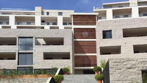 A modern multi-story building with a stone facade, balconies, and a central staircase. - Château by Interhome (Porto Vecchio)