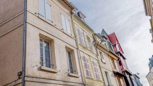 A multi-story building with a beige facade, multiple windows, and a visible gutter system. - Apartment Carnot by Interhome (Deauville-Trouville)
