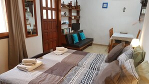 A bedroom with a bed, a sofa, a desk, and a wardrobe. - Studio apartment on rural smallholding, 3km from beaches and amenities (L'Ampolla)