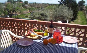 A table set with food and drinks on a balcony overlooking a garden. - Studio apartment on rural smallholding, 3km from beaches and amenities (L'Ampolla)