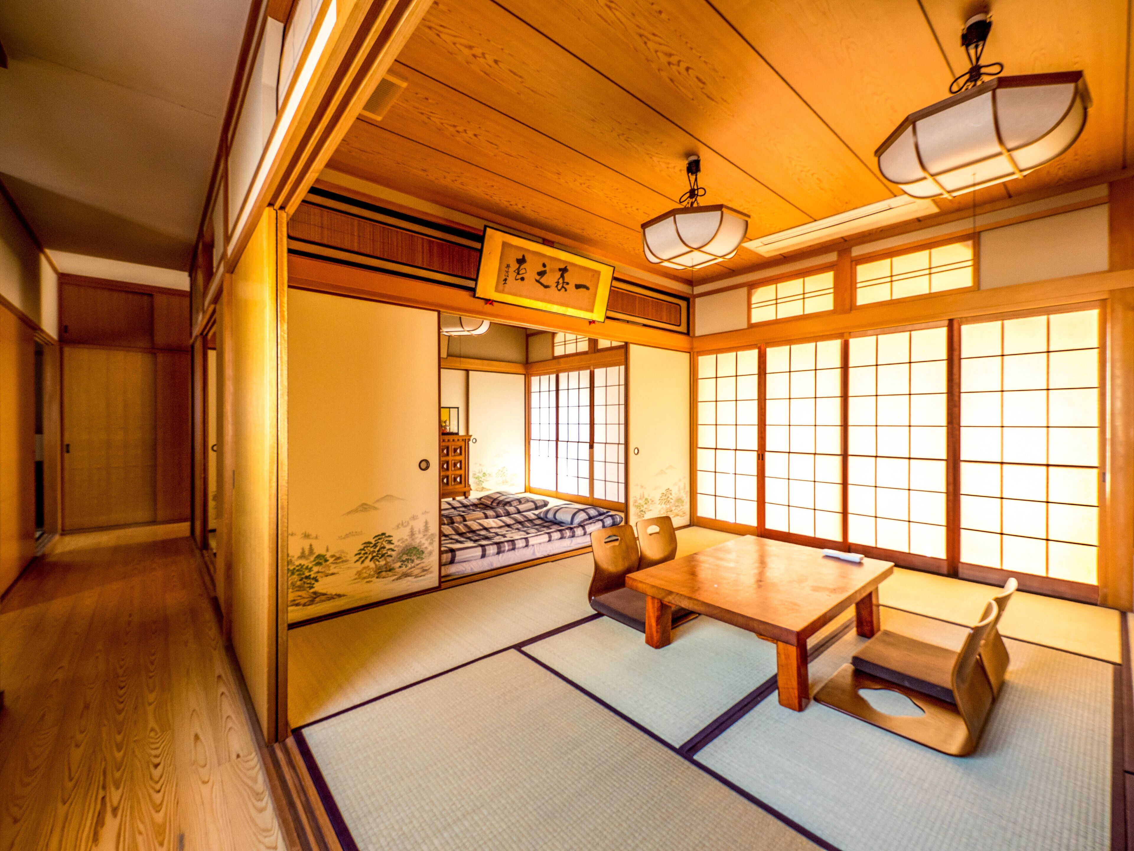 A traditional Japanese room with tatami flooring, a low wooden table, and sliding doors.