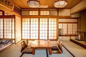 Ein traditioneller japanischer Raum mit Tatami-Bodenbelag, einem niedrigen Holztisch und Shoji-Schirmwänden.