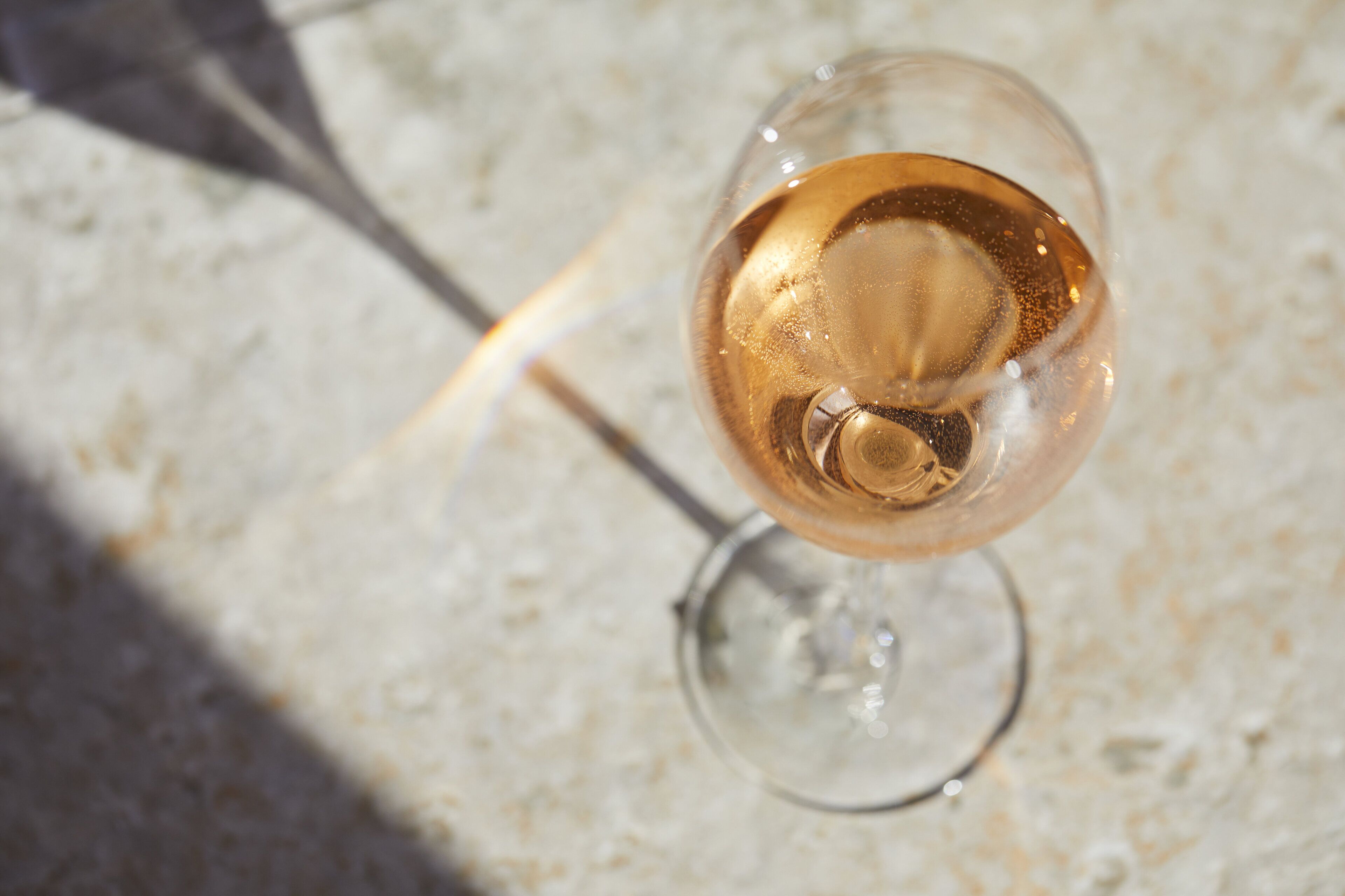 Una copa de vino blanco en una superficie de mármol.