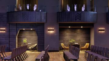 Un intérieur moderne comprenant un coin salon, une cheminée et un balcon agrémenté de guirlandes lumineuses.