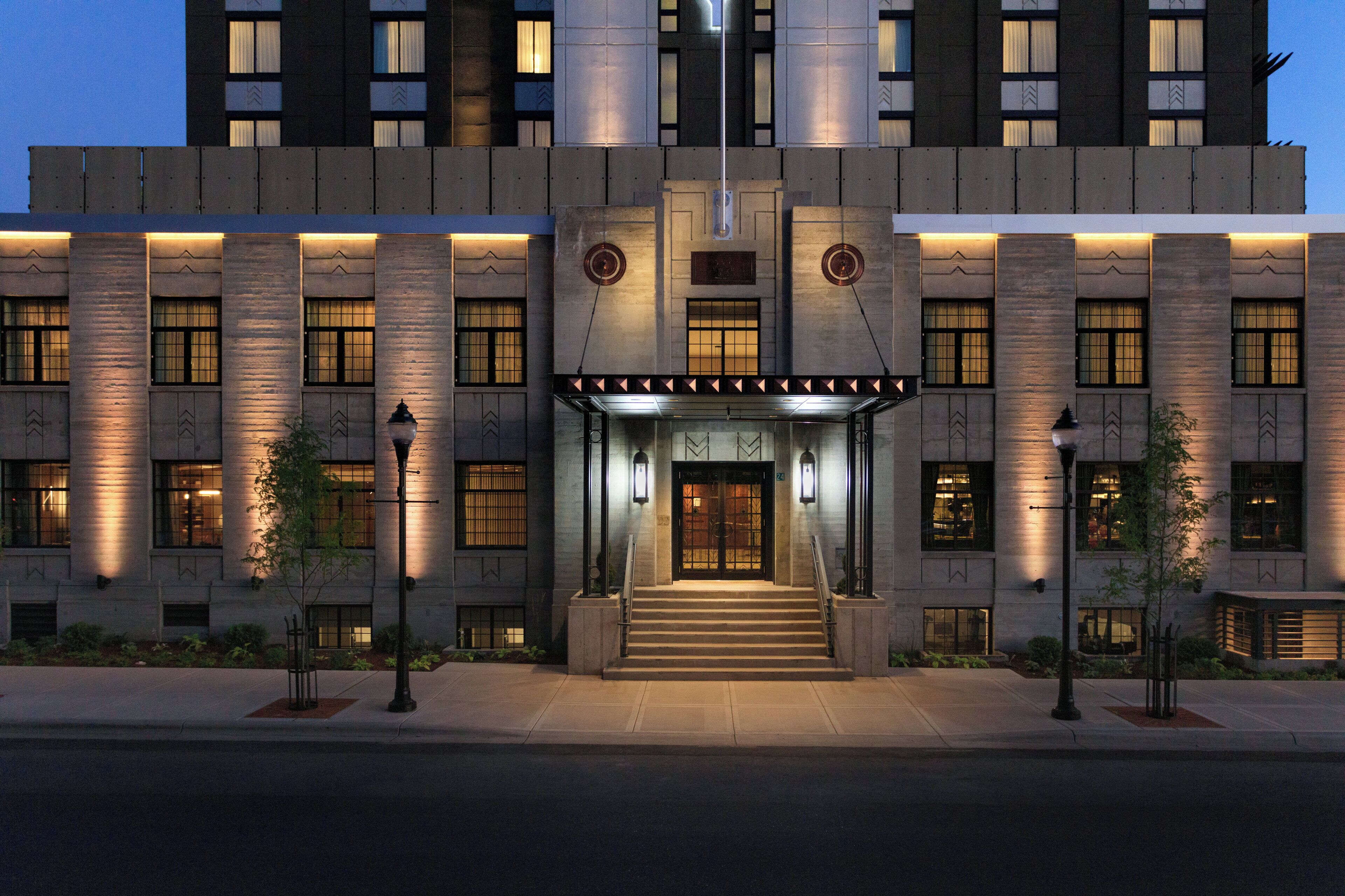 A modern building with a symmetrical facade, large windows, and a central entrance with steps.