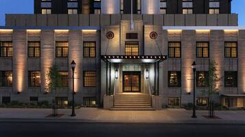 A modern building with a symmetrical facade, large windows, and a central entrance with steps.