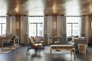 A modern living room with a fireplace, seating area, and large windows. - Kimpton Armory Hotel Bozeman by IHG (Bozeman)