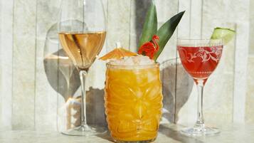 Three glasses of different beverages on a marble surface.