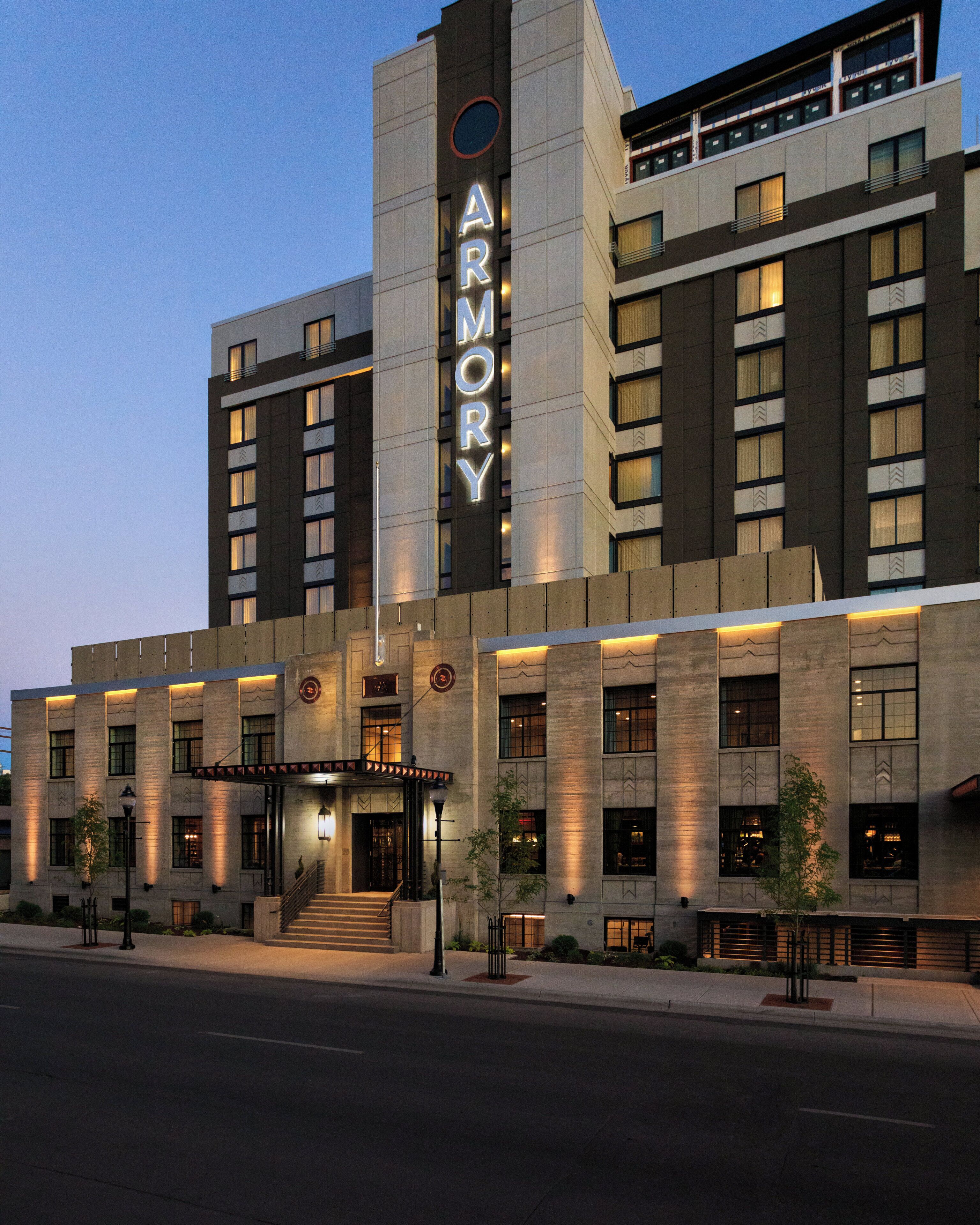A modern hotel with a prominent 'ARMORY' sign, multiple floors, and a well-lit entrance.