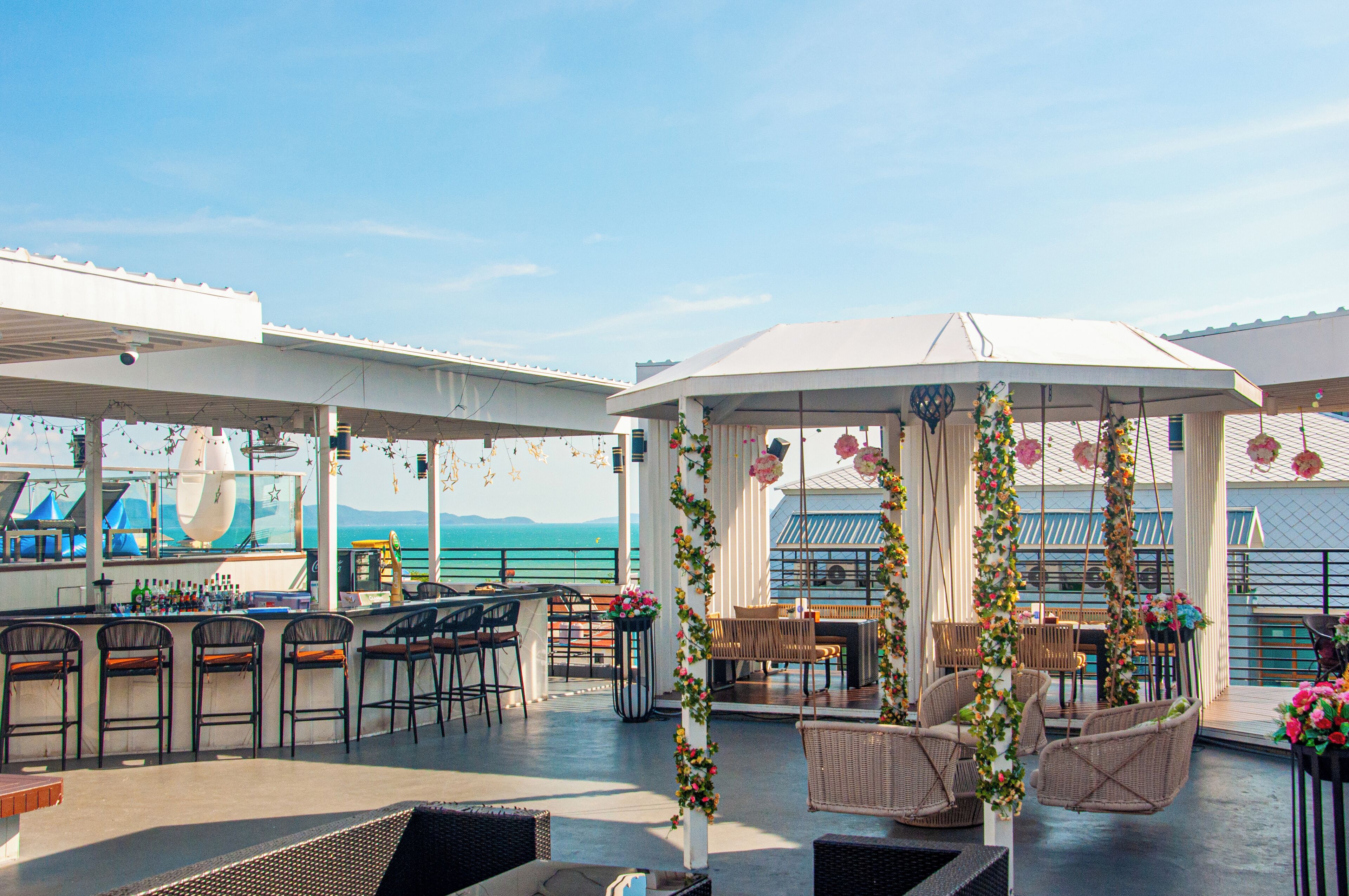 Area bar all'aperto con posti a sedere e vista sull'oceano.