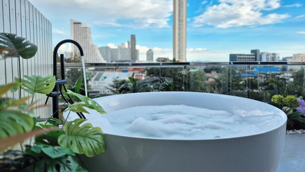 Ein Whirlpool auf einem Balkon mit Blick auf die Stadt.