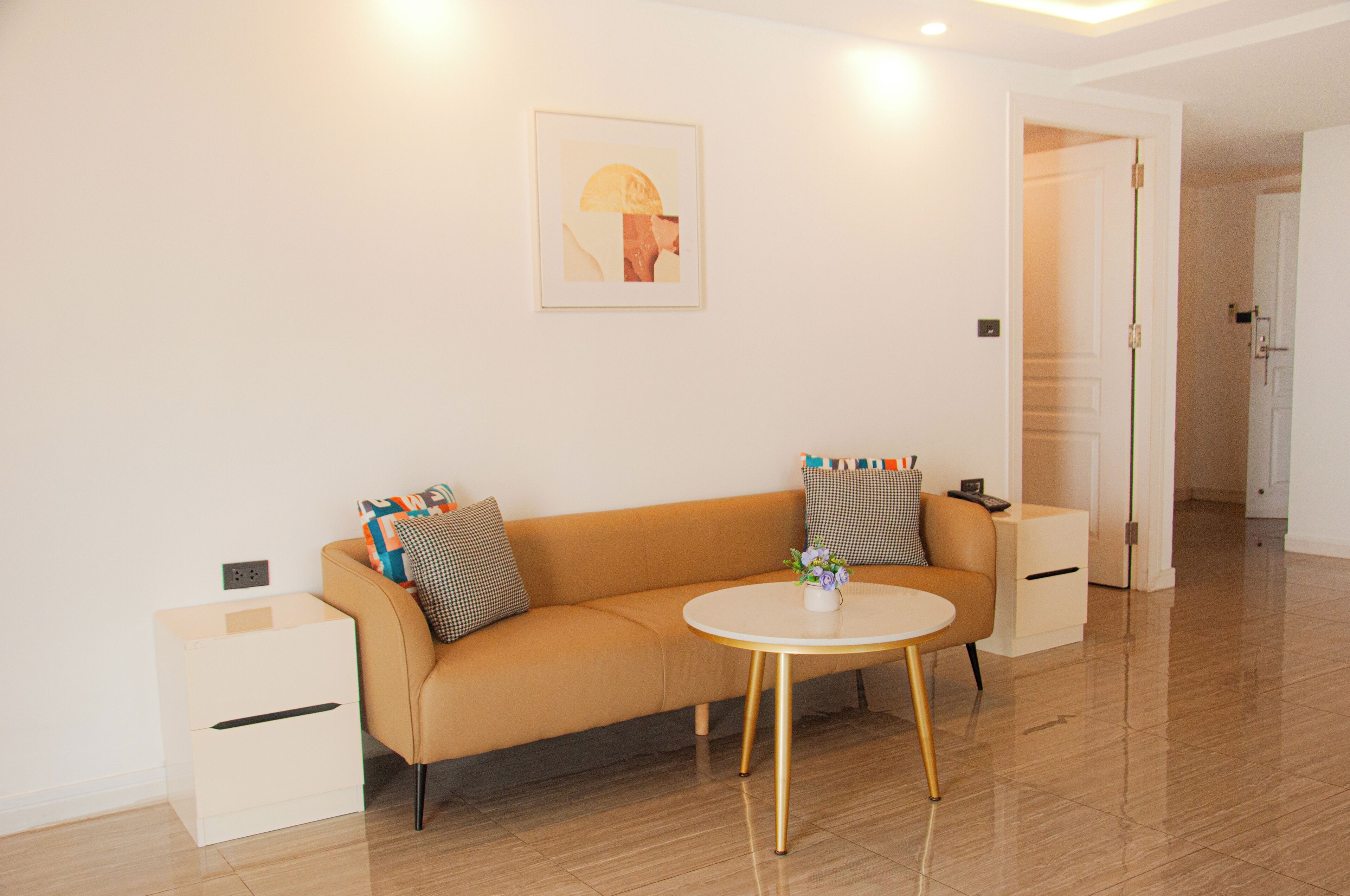 A modern living room with a sofa, a small round table, and a framed picture on the wall.