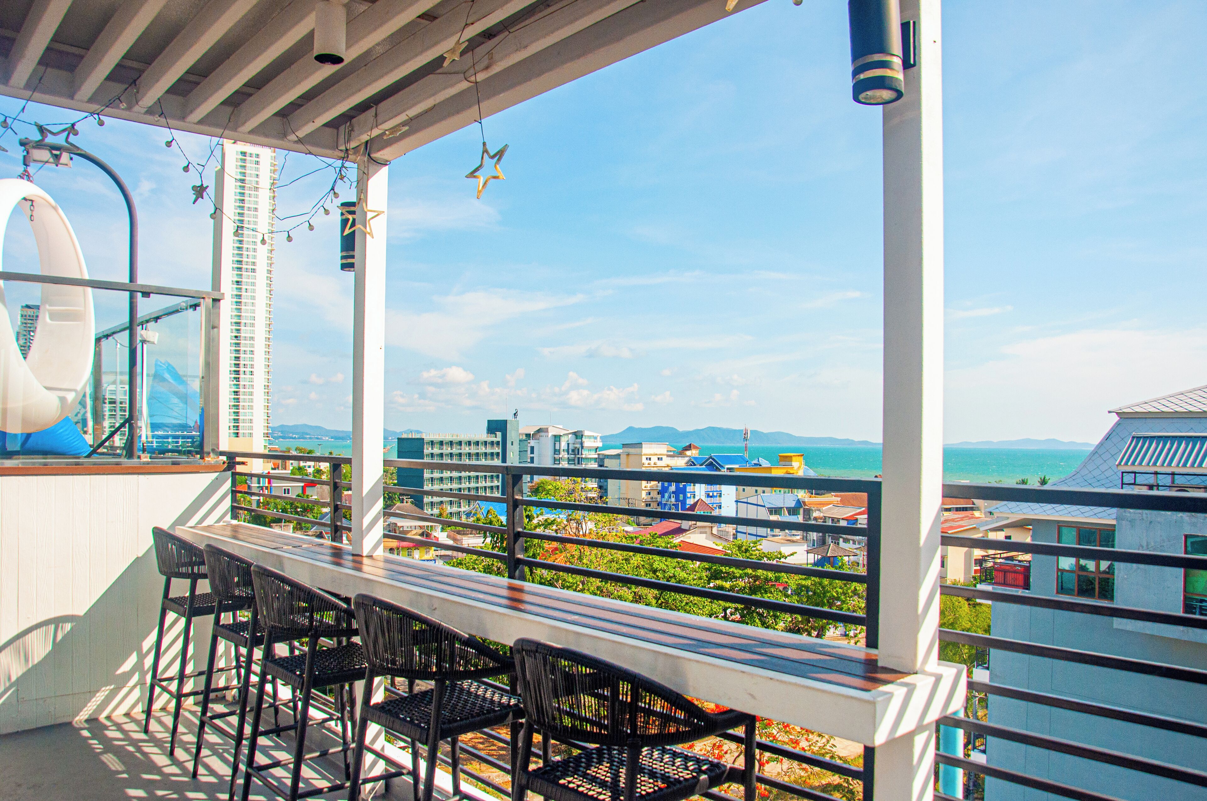 A balcony with a view of a cityscape and the ocean.