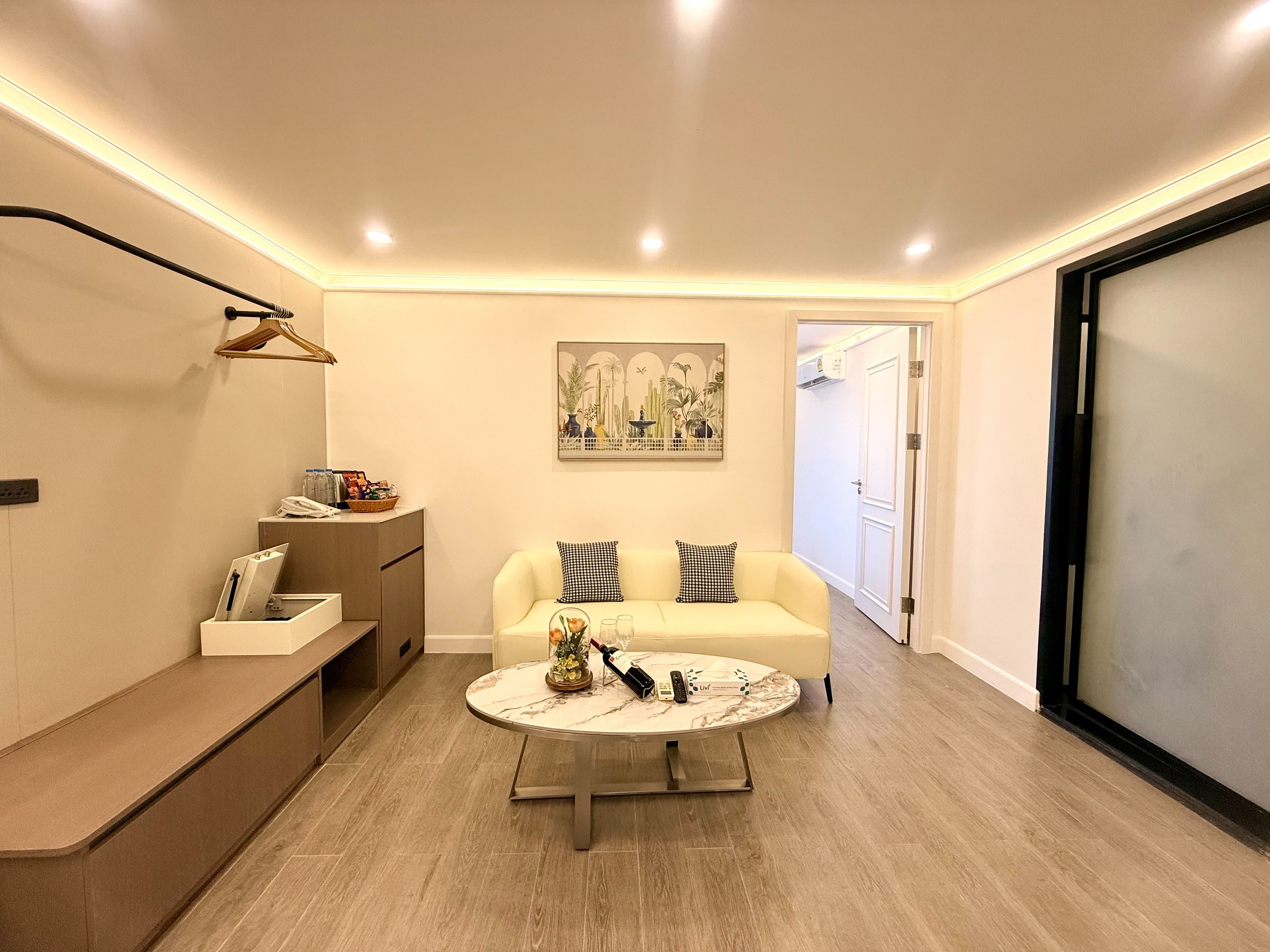 A modern living room with a sofa, a coffee table, and a painting on the wall.
