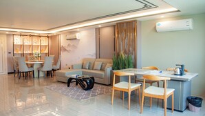 Ein modernes Wohnzimmer mit einer Couch, einem Esstisch, Stühlen und einem Couchtisch.
