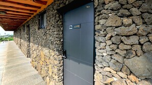 A stone building with a dark door and a sign indicating room number 3.
