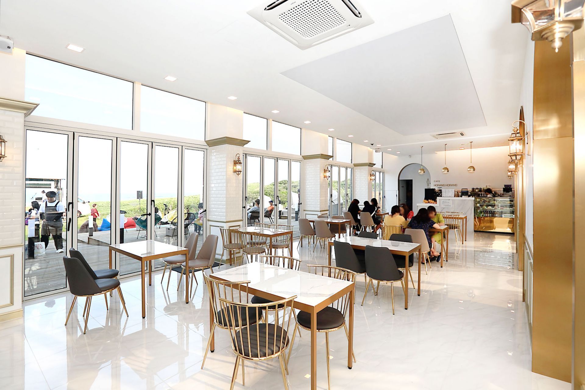 Un ristorante spazioso con ampie vetrate, arredi moderni e un ambiente pulito e luminoso.