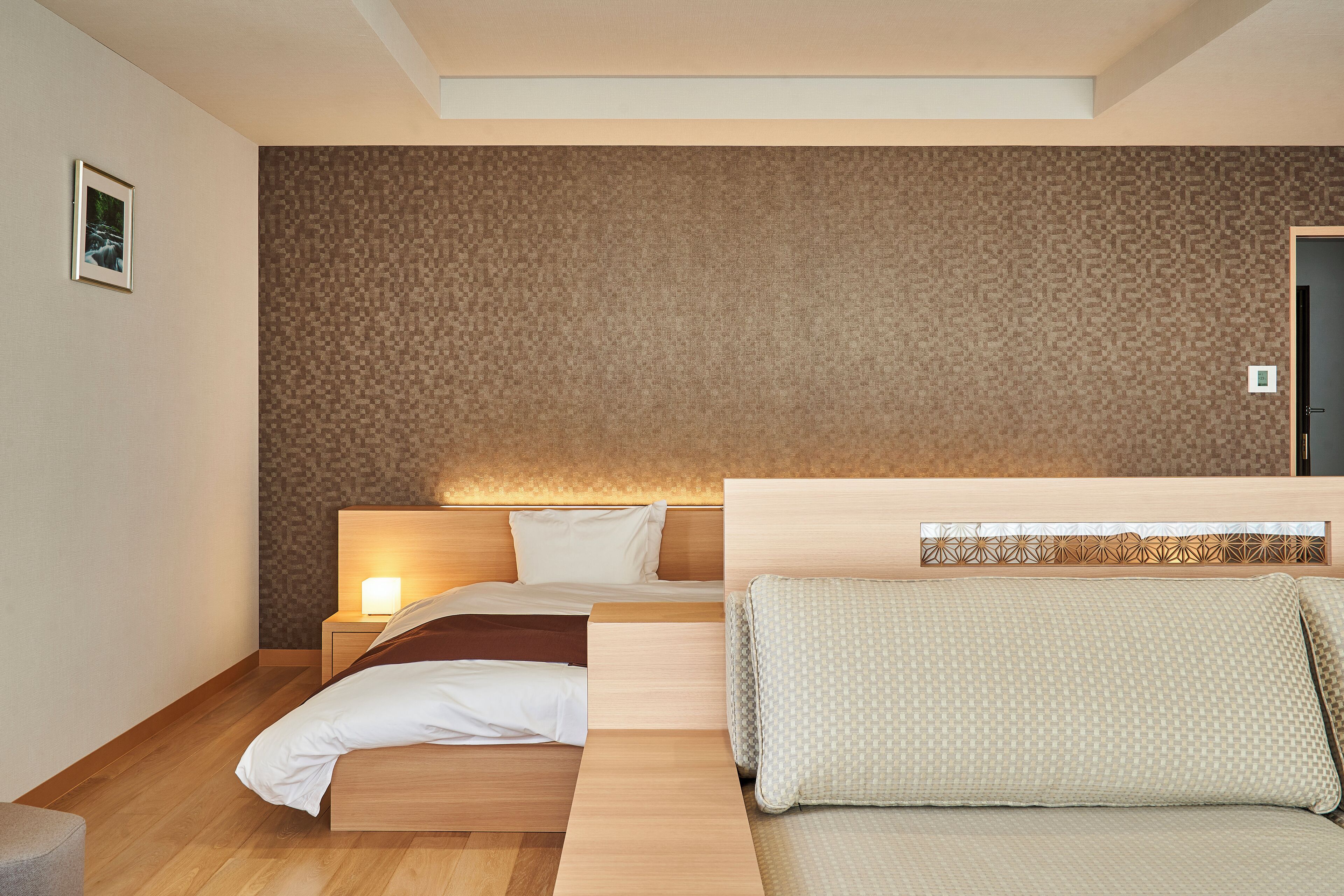 Una camera da letto moderna con un letto, un divano e un comodino.
