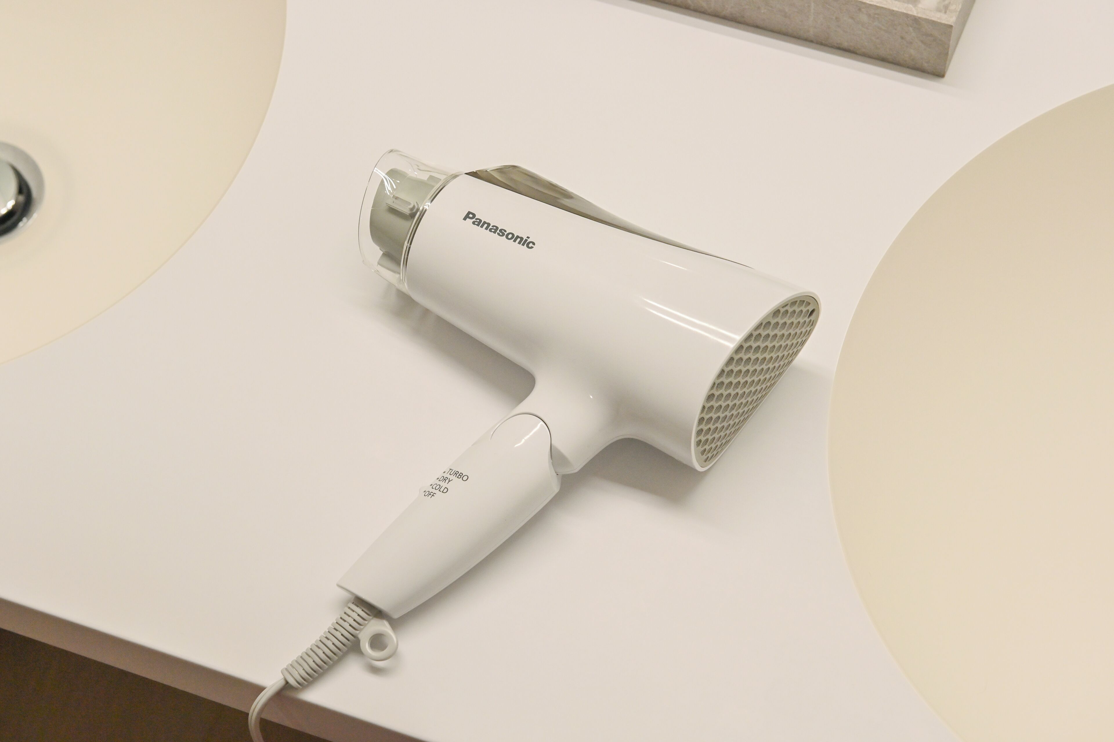 A Panasonic hair dryer on a white countertop.