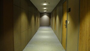 A long, narrow hallway with doors on both sides, recessed lighting on the ceiling, and a carpeted floor. - Lynq Aero (Barasat)
