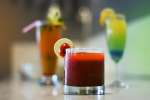 Three cocktails in glasses with garnishes, placed on a reflective surface. - Lynq Aero (Barasat)