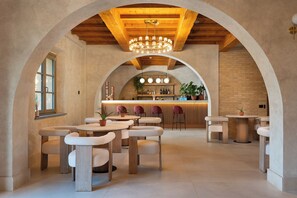 A spacious interior with arched ceilings, a bar area, and multiple seating arrangements.