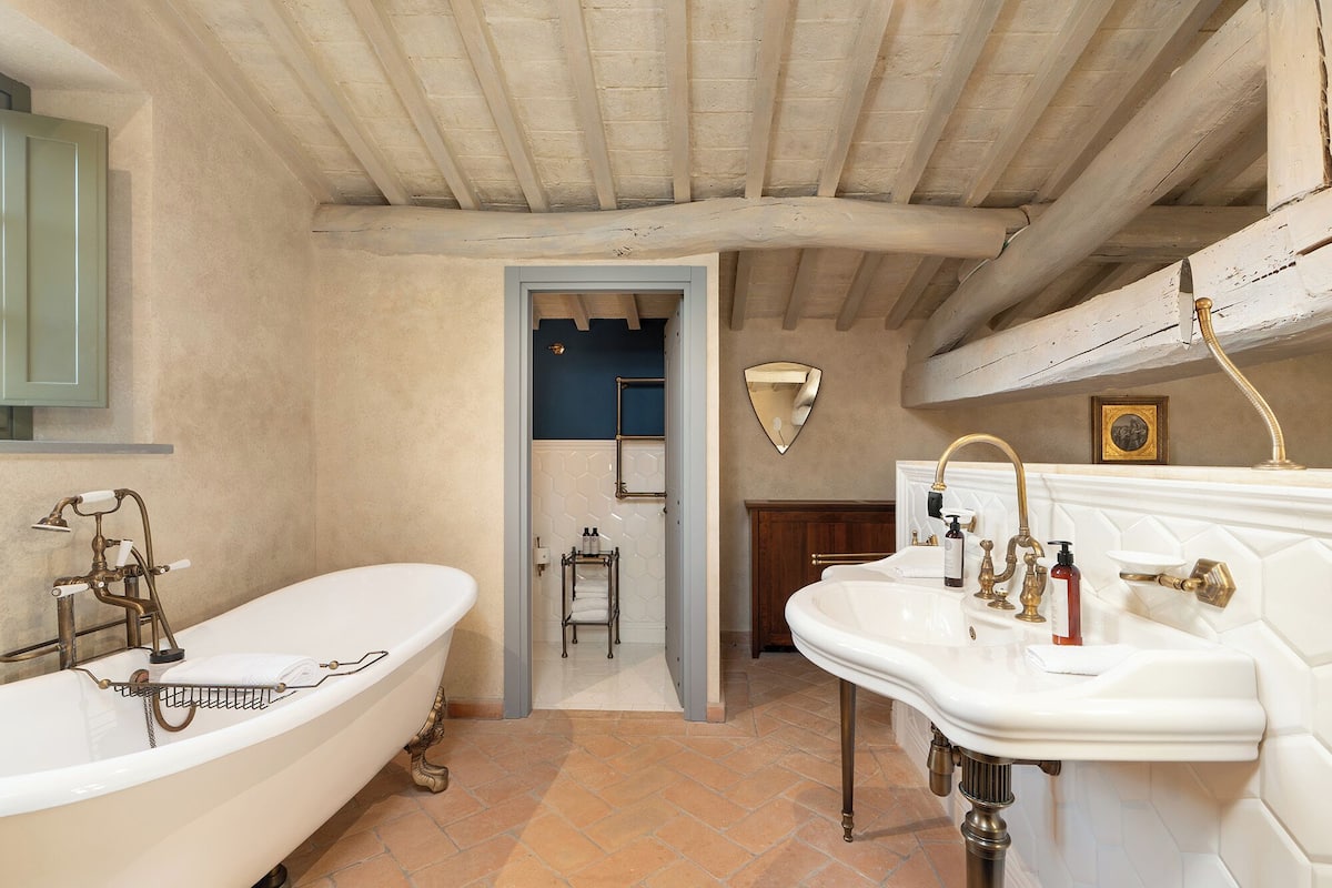 Ein Badezimmer mit freistehender Badewanne, einem Doppelwaschbecken und einer Duschkabine.