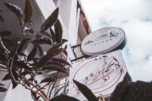 A clock with a bicycle symbol and the text "JIC ISLAND" on a building. - Island House (Kaohsiung)
