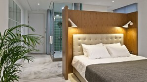 A modern bedroom with a tufted headboard, a large bed, and a bedside lamp. - Island House (Kaohsiung)