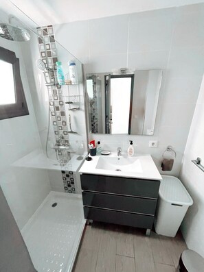Ein modernes Badezimmer mit Dusche, Waschbecken und Toilette.
