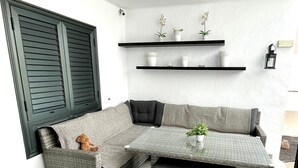 Un rincón de sala con un sofá modular, una mesita y estantes empotrados con objetos decorativos.