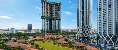 Uma área residencial moderna, com edifícios altos, um espaço verde central e casas ao redor.