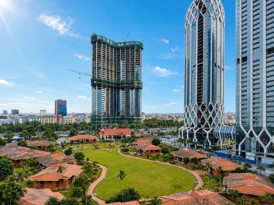 A modern residential area with high-rise buildings, a central green space, and surrounding houses.