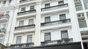 A multi-story hotel with a black awning, a staircase leading to the entrance, and a sign for 'The Nova.'
