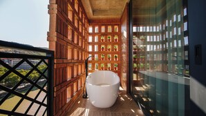 Un baño moderno con una bañera grande, paneles de madera y vistas a un río y edificios.