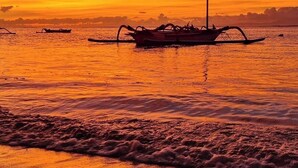 A boat on calm water during sunset. - Balian Yoga Shala (Denpasar)