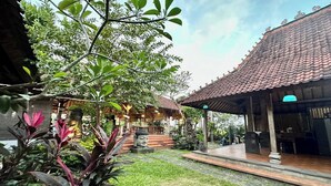 A traditional building with a tiled roof and a covered porch area. - Balian Yoga Shala (Denpasar)